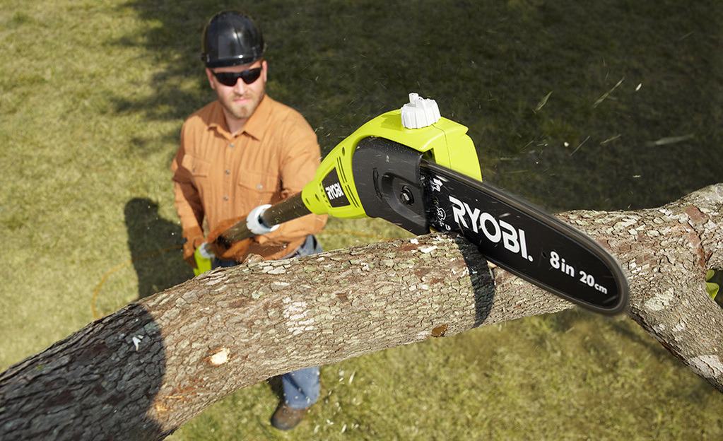 A-man-uses-an-electric-pole-saw-to-cut-a-branch